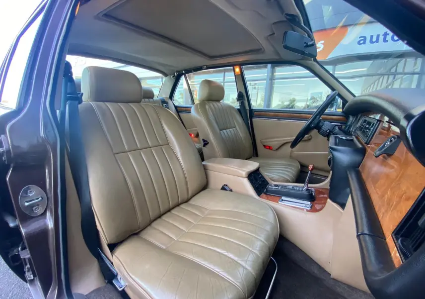 Intérieur beige vue côté gauche de la Jaguar XJ6 Série 3 4.2 Sovereign 1985 avec boiseries et volant noir.