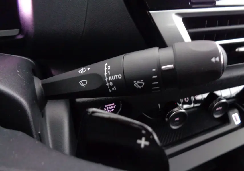 Gros plan sur la commande d'essuie-glace et le bouton start/stop du tableau de bord d'une Citroën C4 gris Artense 2023.