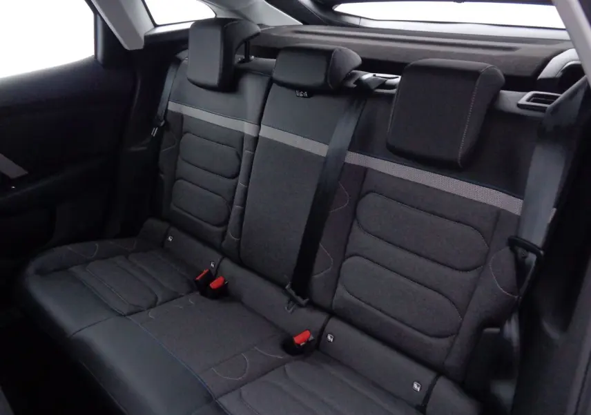 Banquette arrière en tissu gris foncé avec ceinture de sécurité noire dans une Citroën C4 2023 vue de côté intérieur.