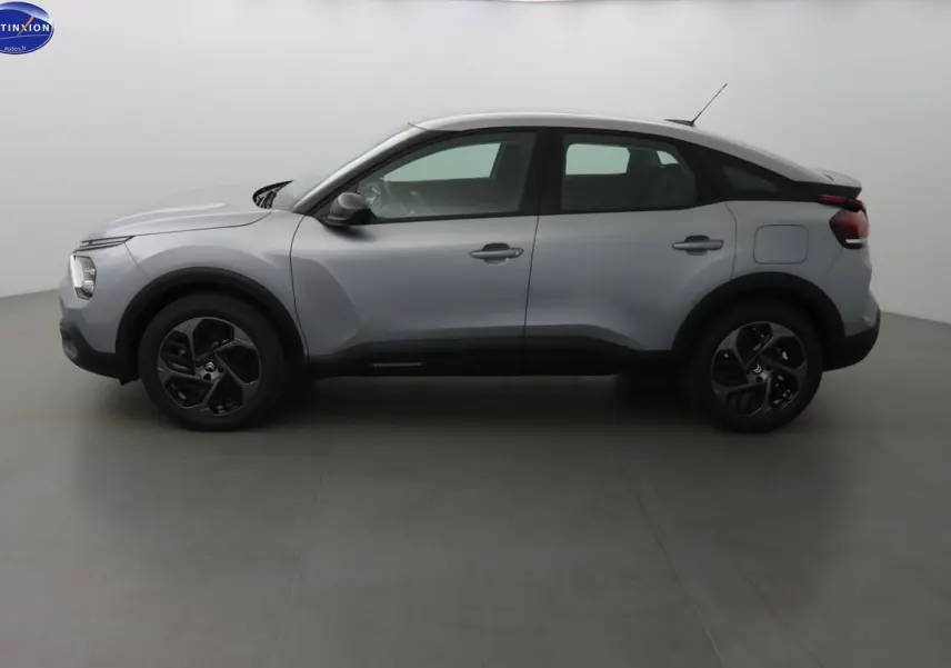 Profil côté gauche d'une Citroën C4 gris Artense métallisé 2023 avec jantes noires bicolores.