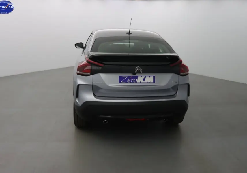 Vue arrière d'une Citroën C4 gris Artense métal 2023 avec double sortie d'échappement et hayon noir contrasté.