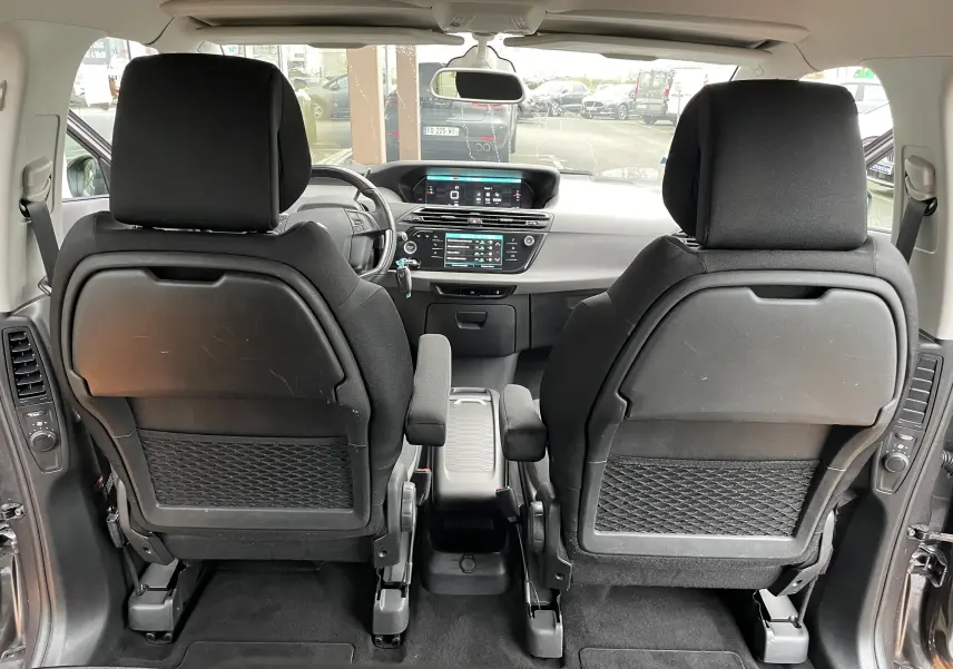 Vue intérieure arrière du Citroën Grand C4 Picasso gris 2018, montrant les sièges avant et le tableau de bord avec écran tactile.