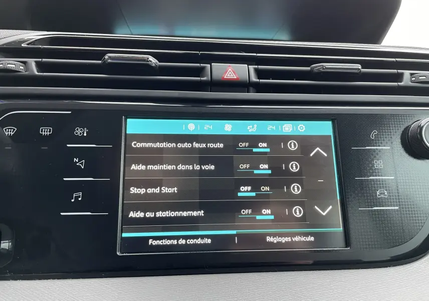 Écran tactile central du tableau de bord du Citroën Grand C4 Picasso gris, affichant les aides à la conduite activées.