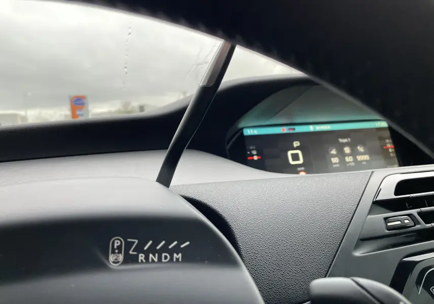 Tableau de bord et compteur numérique du Citroën Grand C4 Picasso gris, vue intérieure côté conducteur avec levier de vitesses automatique.