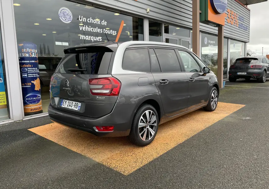 Vue 3/4 arrière droite d'un Citroën Grand C4 Picasso gris 2018, avec feux arrière distinctifs et toit blanc contrastant.