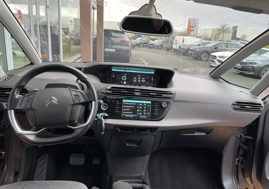 Vue intérieure avant du tableau de bord gris du Citroën Grand C4 Picasso 2018 avec écran tactile et volant multifonction.
