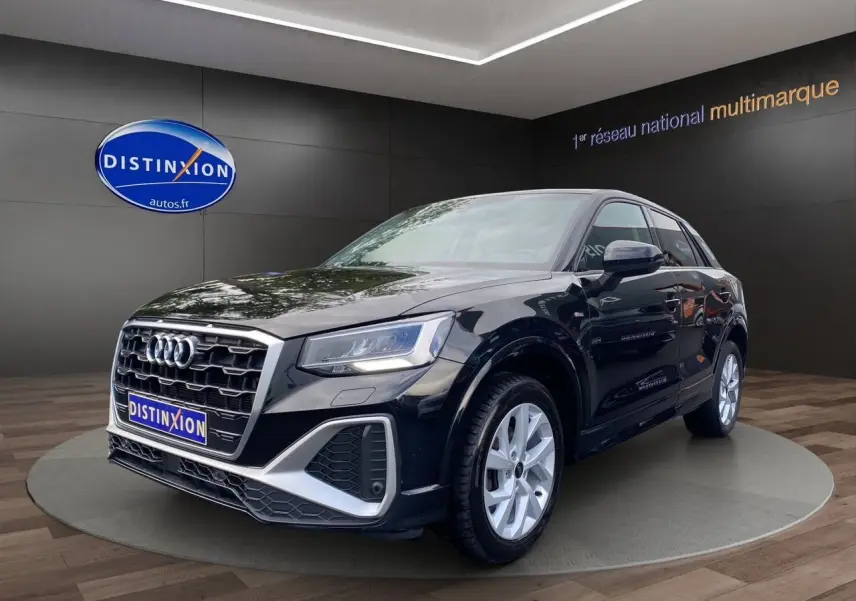 Audi Q2 noir mito en 3/4 avant droit, mettant en valeur ses jantes alliage 17 pouces et son design S-Line sportif.