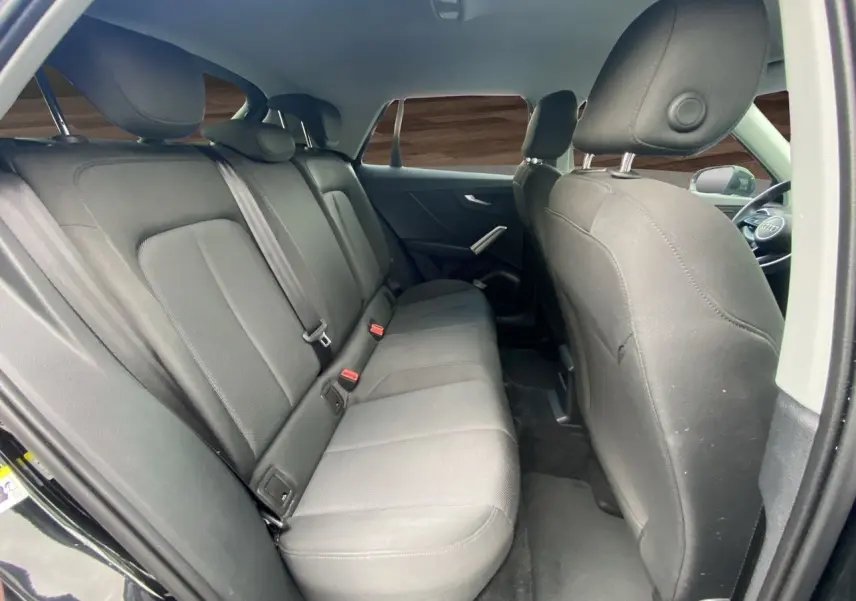 Vue intérieure côté droit montrant la banquette arrière en tissu noir du Audi Q2 35 TFSI S-Line 2023.