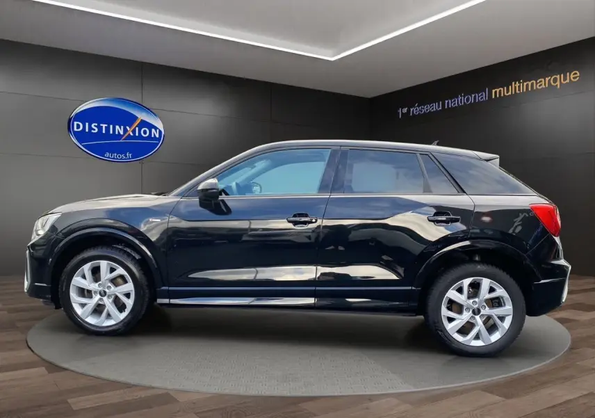 Audi Q2 noir mito vue de profil côté gauche, avec jantes alliage 17 pouces et toit panoramique visible.