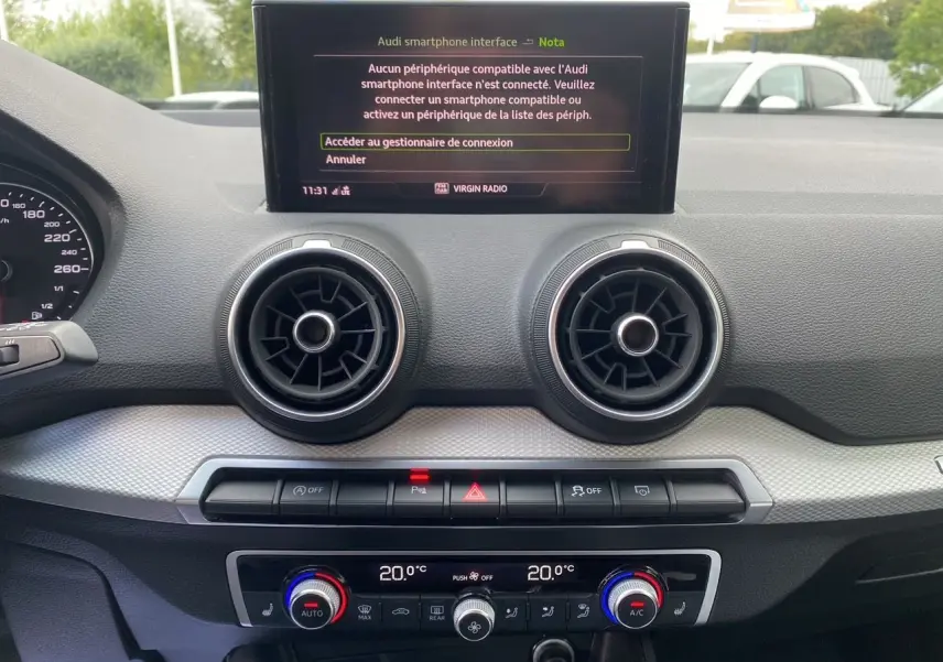 Coffre ouvert d'un Audi Q2 noir mito 2023, vue intérieure montrant un espace de chargement propre et spacieux.