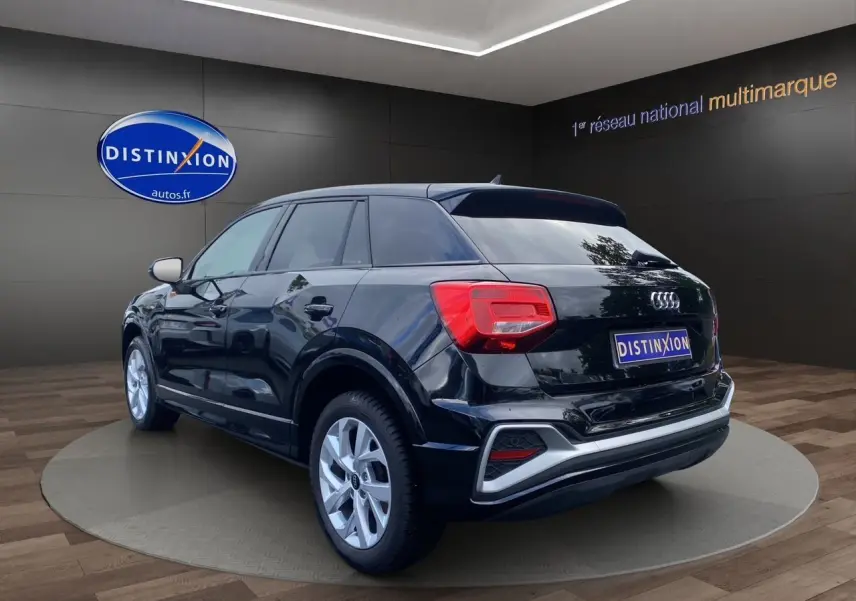 Audi Q2 noir mito vue 3/4 arrière droit, jantes alliage 17 pouces et hayon motorisé visible en showroom.