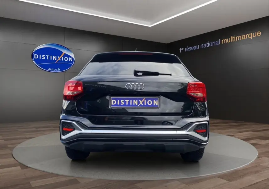 Vue arrière d'un Audi Q2 noir mito 2023 avec hayon motorisé et feux LED dans un showroom.