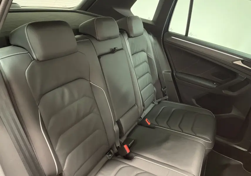 Vue intérieure côté droit des sièges arrière en cuir noir avec surpiqûres blanches du Volkswagen Tiguan 2024 Nightshade Blue.