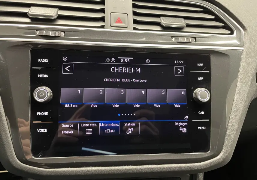Écran tactile central du Volkswagen Tiguan 2024 affichant la radio CHERIEFM, entouré de commandes médias et climatisation.