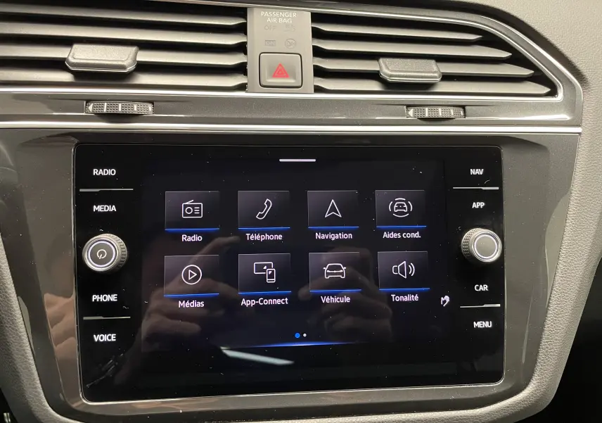 Écran tactile central du Volkswagen Tiguan 2024 affichant le menu multimédia et aides à la conduite.