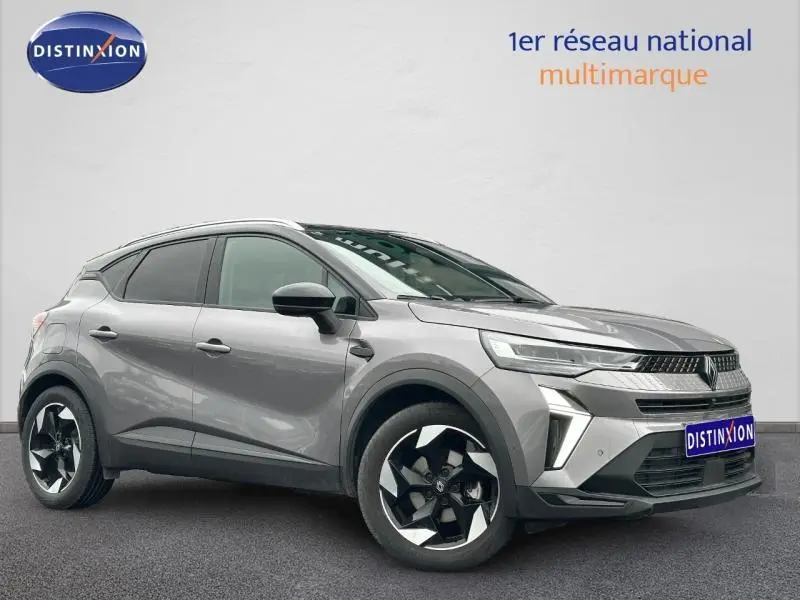 Renault Captur 1.6 E-Tech hybride 2025 gris, vue 3/4 avant droit avec jantes noires et détails modernes.
