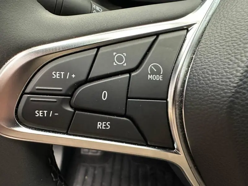 Gros plan sur les commandes noires du régulateur de vitesse au volant du Renault Captur 1.6 E-Tech hybride 2025.
