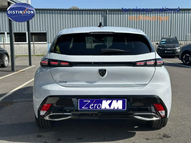 Vue arrière d'une Peugeot 308 blanche de 2025 avec feux arrière LED et double sortie d'échappement chromée.