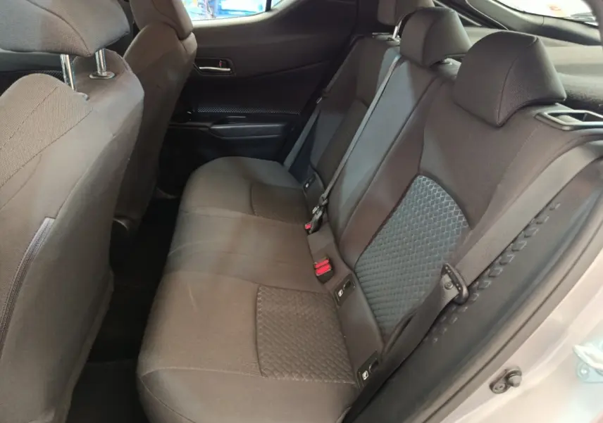 Vue côté droit de la banquette arrière grise avec appuie-têtes et ceintures de sécurité du Toyota C-HR 2.0 Hybride 184.