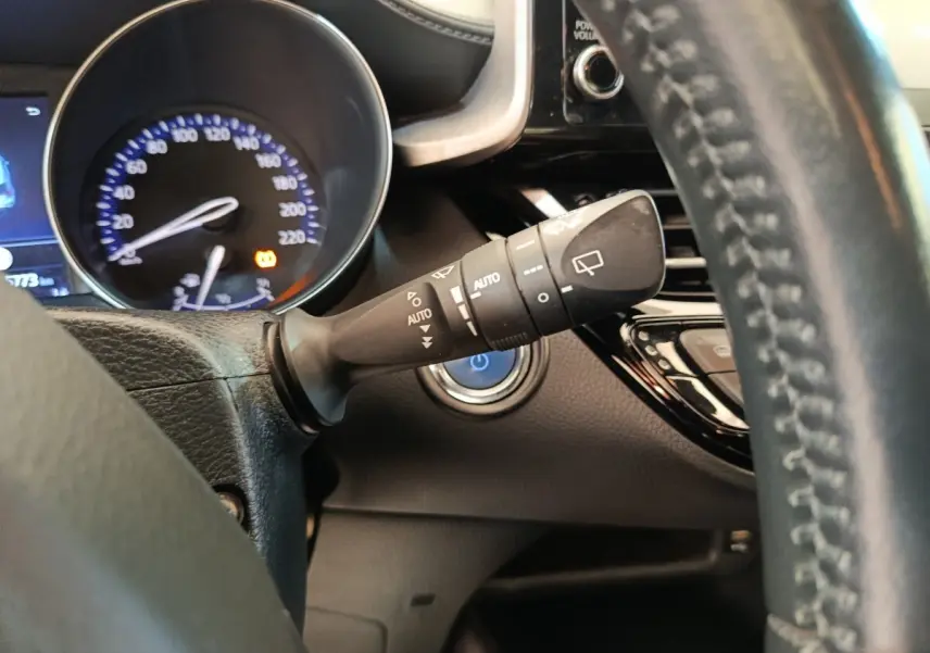 Gros plan sur la commande d’essuie-glace à gauche du volant en cuir noir du Toyota C-HR hybride 2022.