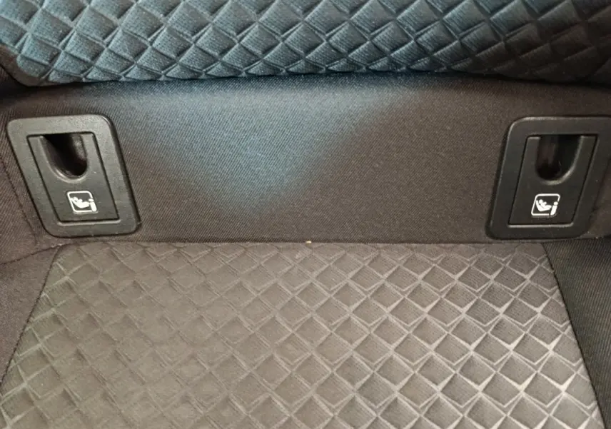 Détail de la banquette arrière en tissu gris avec attaches Isofix visibles dans un Toyota C-HR hybride 2022.