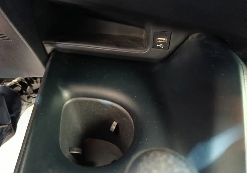 Gros plan sur le porte-gobelet noir et port USB intégré dans l'habitacle du Toyota C-HR hybride 2022.