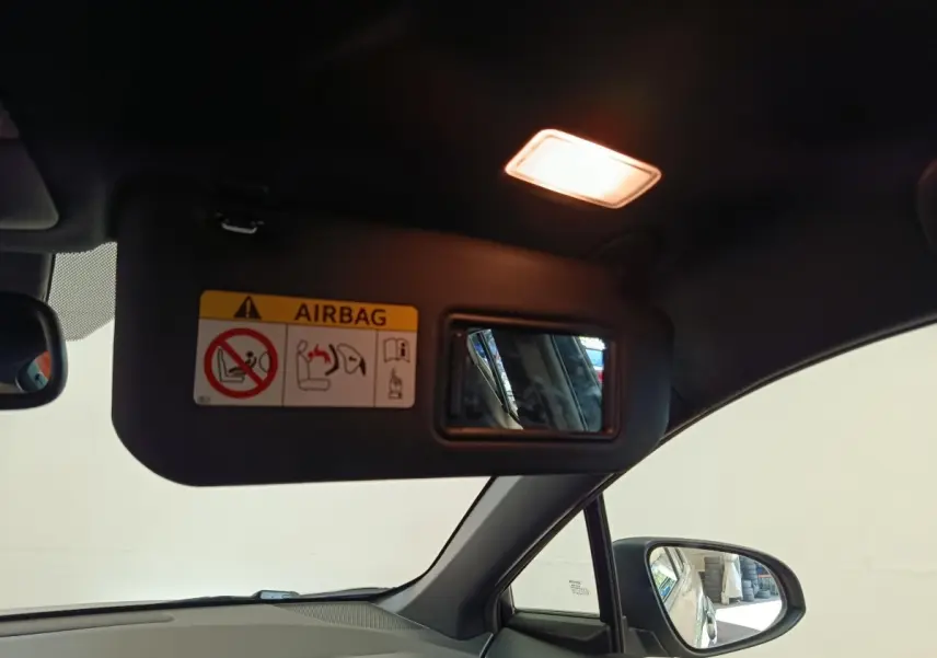 Vue intérieure du pare-soleil côté conducteur avec miroir et lumière allumée dans un Toyota C-HR gris clair.