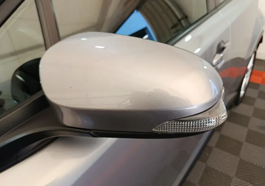 Rétroviseur côté gauche gris clair du Toyota C-HR 2.0 Hybride 184, avec clignotant intégré, vue rapprochée.