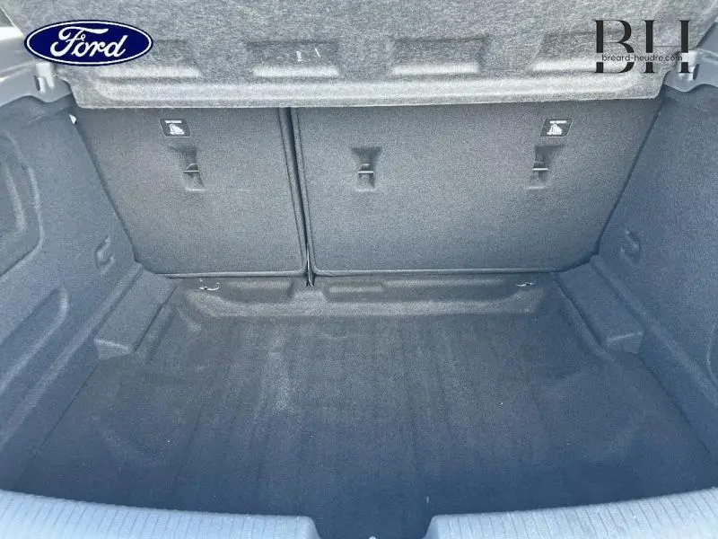 Coffre vide vu de face, intérieur gris foncé, montrant la banquette arrière rabattable de l'Opel Astra.