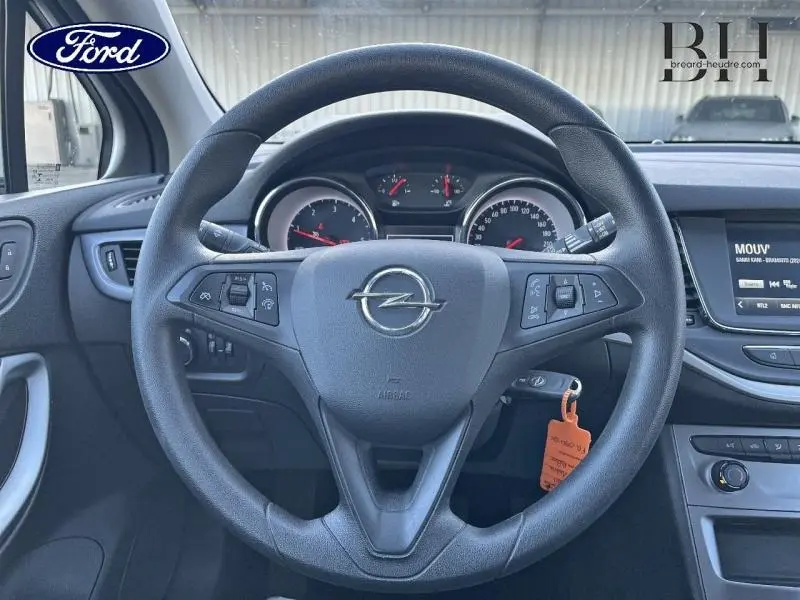 Vue intérieure centrée sur le volant noir de l'Opel Astra 2020 avec tableau de bord et écran tactile visibles.