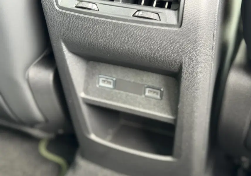 Vue rapprochée des ports USB arrière et rangement central en plastique noir dans l’habitacle de la Peugeot 308 gris Artense.