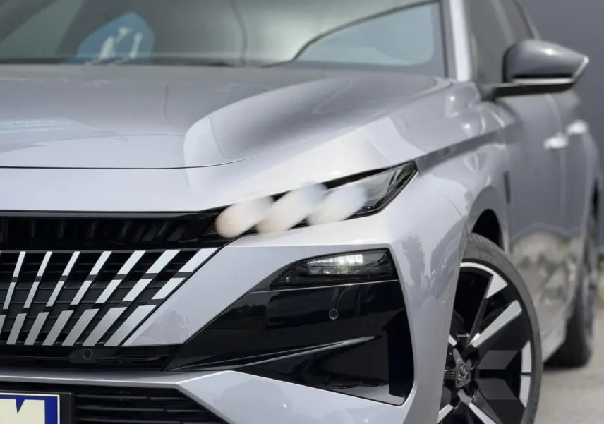 Vue avant droite rapprochée d’une Peugeot 308 gris Artense avec calandre distinctive et jante bi-ton 18 pouces.