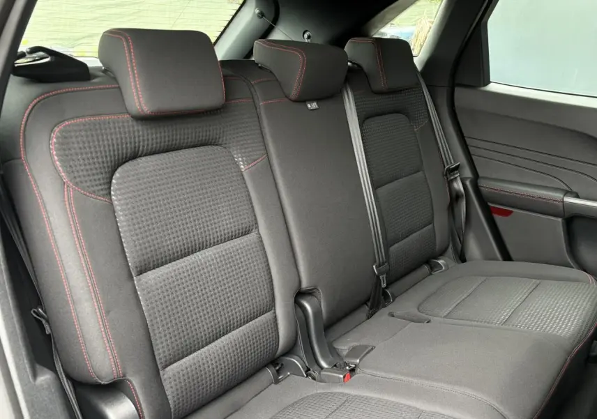 Vue latérale des sièges arrière noirs avec surpiqûres rouges du Ford Kuga 2.0 EcoBlue 120 BVA ST-Line 2023.