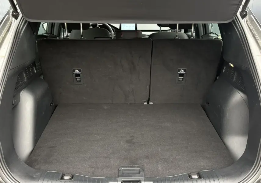 Coffre ouvert vu de l'arrière du Ford Kuga gris graphite, montrant l'espace de chargement et les dossiers arrière rabattus.