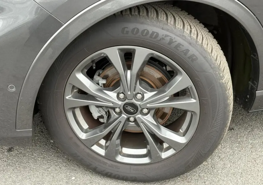 Gros plan sur la roue avant droite gris graphite du Ford Kuga 2023 avec jante alliage 18 pouces et pneu Goodyear.