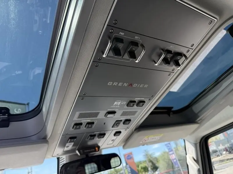 Vue intérieure du plafond avec panneau de commandes et logo Grenadier dans un INEOS Grenadier beige 2024.
