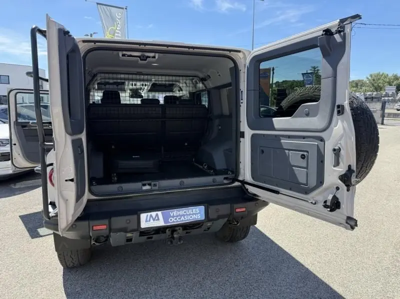 Vue arrière ouverte de l'INEOS Grenadier beige 2024, version Quartermaster avec coffre spacieux et porte-roue de secours.