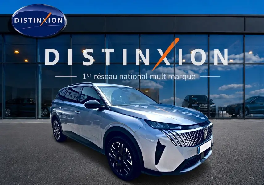 Peugeot 5008 Hybrid 145 allure e-dcs6 gris artense en 3/4 avant droit devant une vitrine Distinxion.