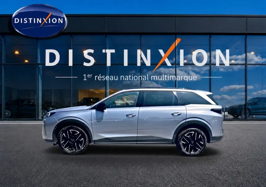 Peugeot 5008 Hybrid 145 allure e-dcs6 gris artense en profil droit devant une vitrine Distinxion.