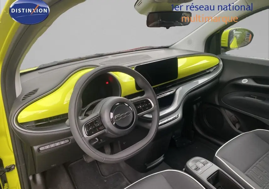 Intérieur avant droit de la FIAT 500 électrique jaune acid avec tableau de bord et volant noirs et jaunes.