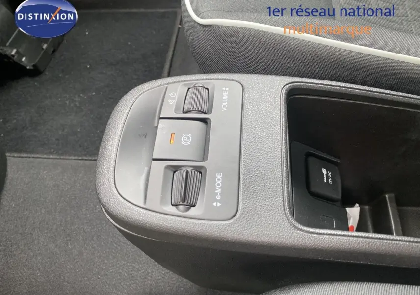 Gros plan sur la console centrale de la Fiat 500 électrique 2024, montrant les commandes e-mode et volume.