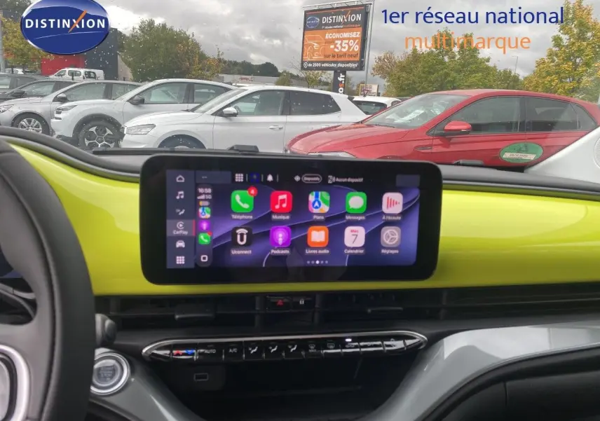 Vue intérieure du tableau de bord de la FIAT 500 électrique 2024 en jaune acid, avec écran tactile central allumé.