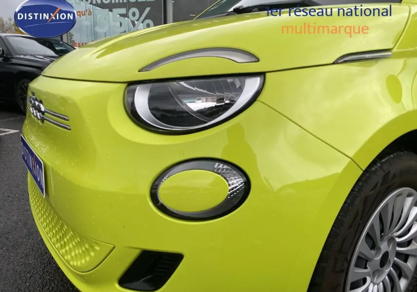 Vue de 3/4 avant droit d'une FIAT 500 électrique 2024 en jaune acid avec phares ronds et jantes argentées.