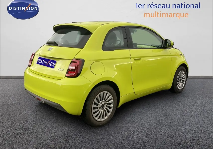 Fiat 500 électrique jaune acid vue 3/4 arrière côté droit sur fond neutre avec jantes originales.