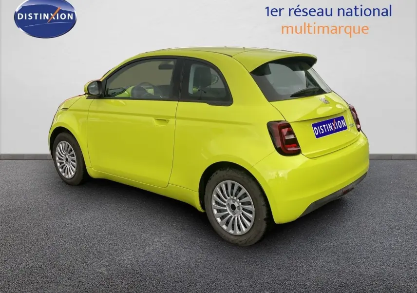 Vue 3/4 arrière droite d'une FIAT 500 électrique 2024 en jaune acid avec feux arrière foncés et jantes argentées.