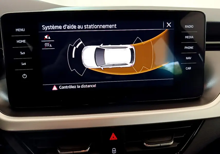 Écran tactile intérieur du Skoda Kamiq 2022 affichant l'aide au stationnement avec alertes de distance