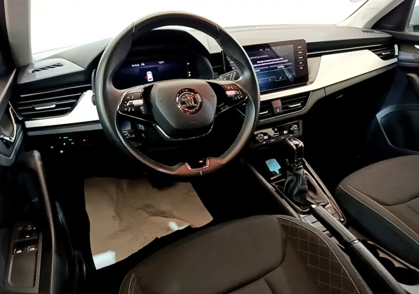 Intérieur du Skoda Kamiq 2022 vu côté conducteur, volant cuir, tableau de bord digital et console centrale noire.