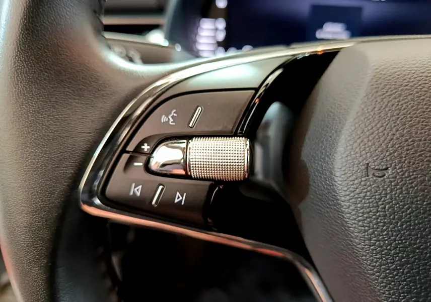 Gros plan sur les commandes gauche du volant cuir du Skoda Kamiq 2022, boutons de volume et voix intégrée.