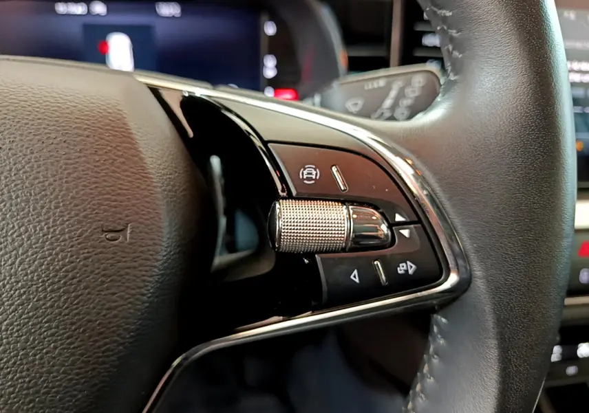 Gros plan sur les commandes multifonctions côté gauche du volant cuir du Skoda Kamiq gris clair 2022.