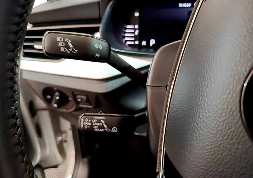 Détail des commandes au volant d'une Skoda Kamiq 2022, vue rapprochée côté gauche avec tableau de bord numérique.